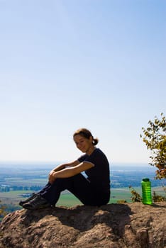 sitting woman on top of a mountain