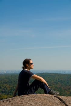 sitting woman on top of a mountain