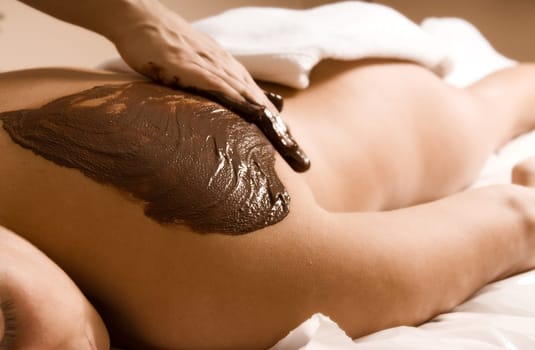 young woman getting a chocolate massage at a spa
