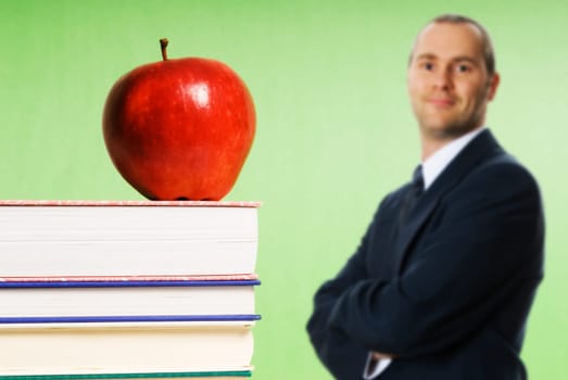 apple sitting on top of books in a classroom