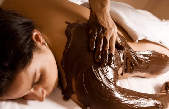 young woman getting a chocolate massage at a spa