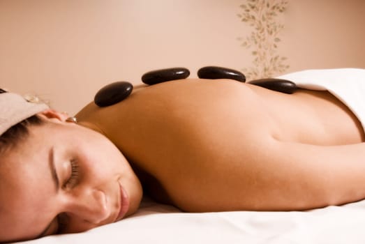 young woman getting a stone massage at a spa