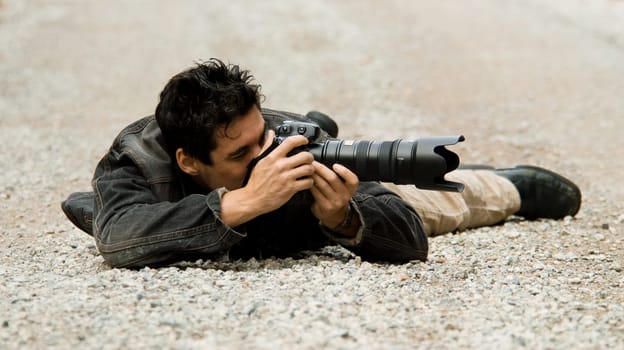 paparazzi photographer hiding on the ground to get shot