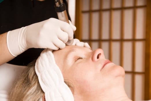 older woman getting electrolysis on he face
