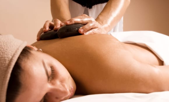 young woman getting a stone massage at a spa