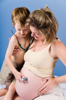 cute blond boy listening to the unborn child