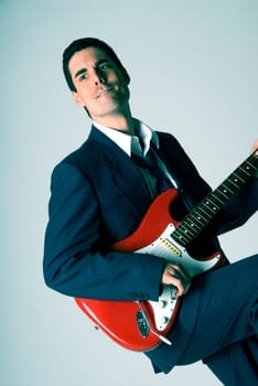 man in blue suit with a red guitar