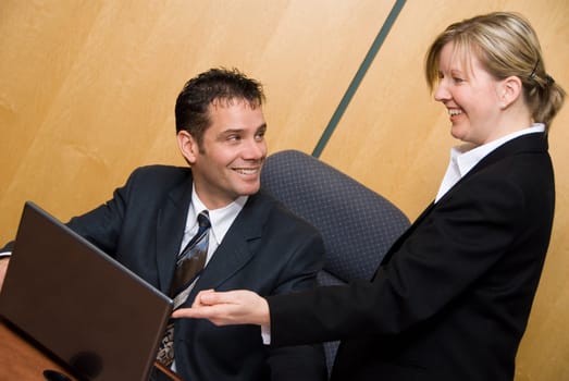 man and woman in a room with a laptop happy