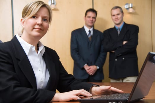 3 people looking at the camera with a laptop