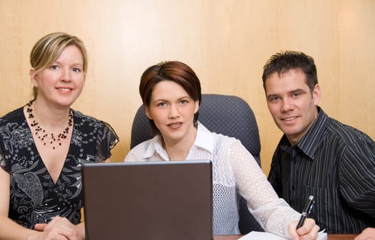 serious colleagues in an office with a laptop