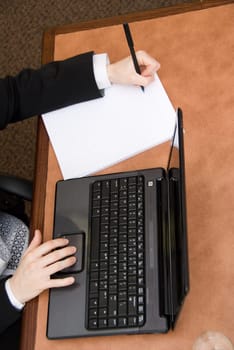 woman in a boardroom taking some notes