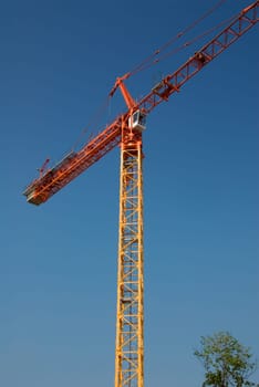 construction crane in orange on a blue sky