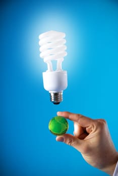 a hand with a floating light bulb and a planet