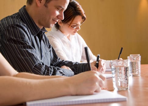 business people writing in a meeting room