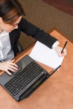 woman in a boardroom taking some notes