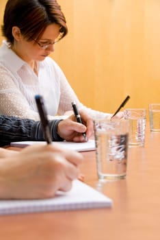 business people writing in a meeting room