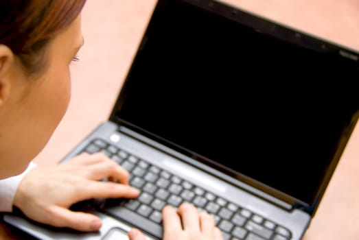 woman in a meeting typing on her laptop
