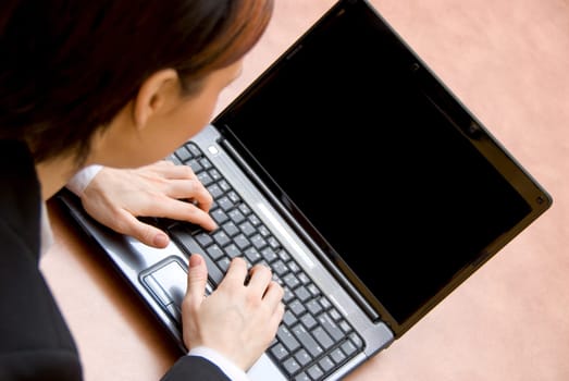 woman in a meeting typing on her laptop