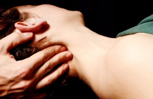 woman getting a massage in a spa on black