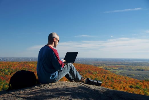 male photographer shooting at the top of a mountain