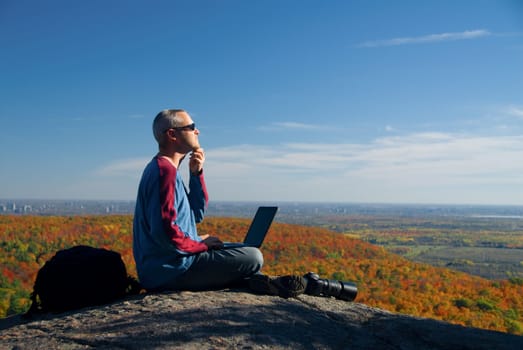 male photographer shooting at the top of a mountain
