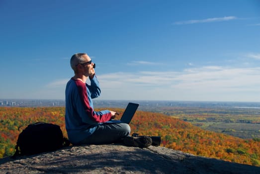 laptop photographer on the phone on the mountain