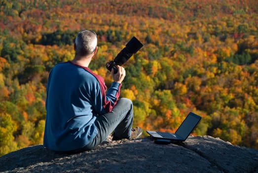 male photographer shooting at the top of a mountain