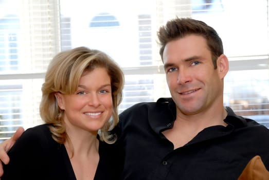 happy pair sitting on the sofa holding each other