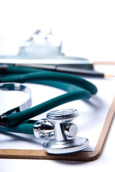 Stethoscope in green on clip board on white