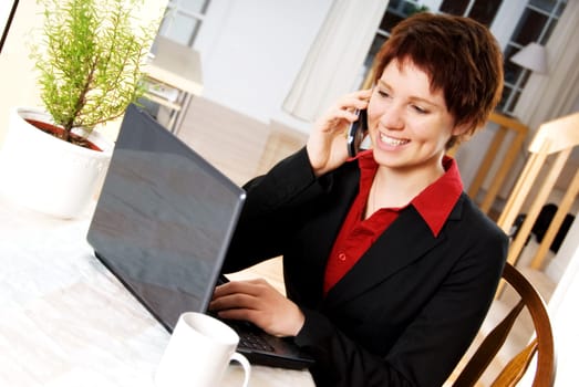 woman in a suit on the cell phone with laptop
