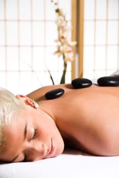 woman getting a hot stone massage at a day spa