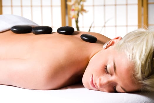 woman getting a hot stone massage at a day spa