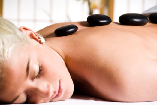 woman getting a hot stone massage at a day spa