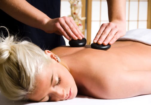 woman getting a hot stone massage at a day spa
