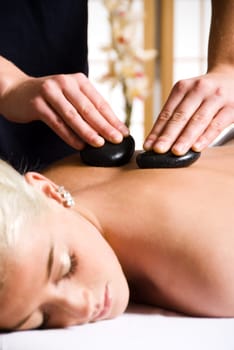 woman getting a hot stone massage at a day spa