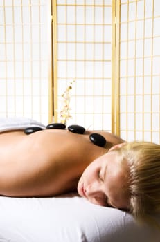 woman getting a hot stone massage at a day spa
