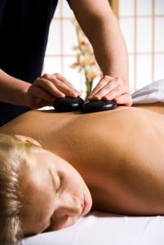 woman getting a hot stone massage at a day spa