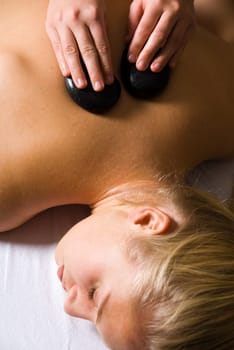 woman getting a hot stone massage at a day spa