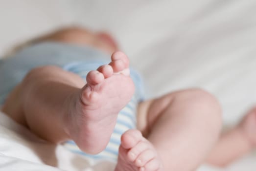 sleeping baby on a white blanket with feet