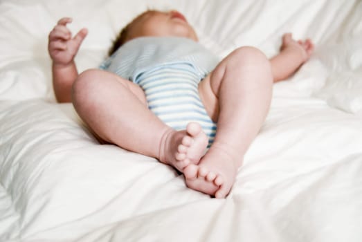 sleeping baby on a white blanket with feet