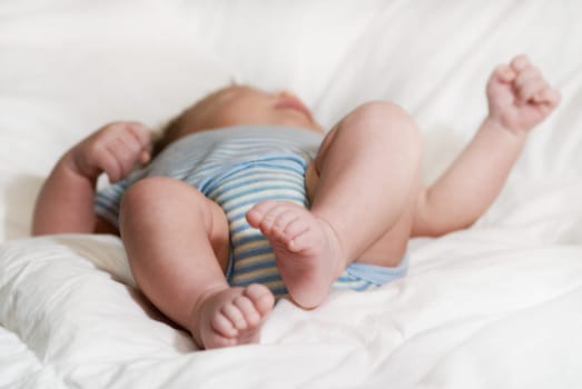 sleeping baby on a white blanket with feet