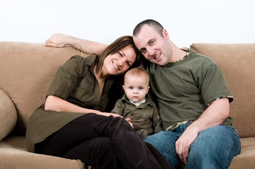 mom and dad on a sofa with their baby boy