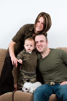 mom and dad on a sofa with their baby boy