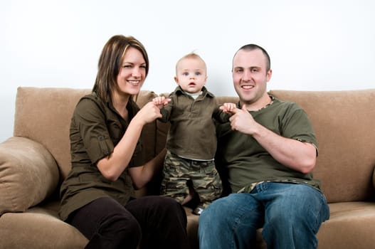 mom and dad on a sofa with their baby boy