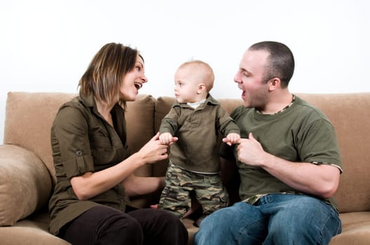 mom and dad on a sofa with their baby boy
