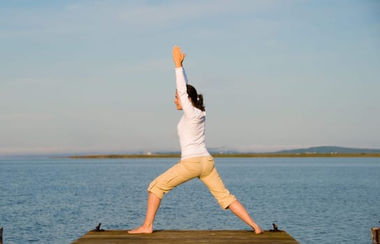 Yoga Woman on a dock by the ocean