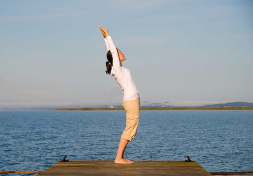 Yoga Woman on a dock by the ocean