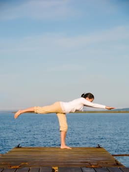 Yoga Woman on a dock by the ocean