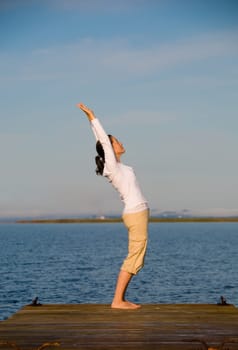 Yoga Woman on a dock by the ocean