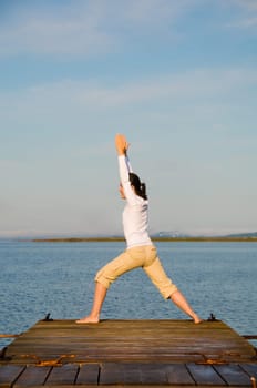 Yoga Woman on a dock by the ocean